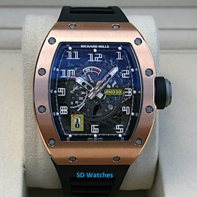SkeletonRichard Mille watch with a rose-gold bezel, black strap, and exposed gears visible through a blue-tinted dial.