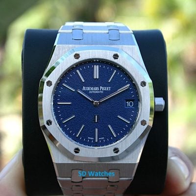 Audemars 16202BC | SD Watches Close-up of an Audemars Piguet stainless steel watch with a blue textured dial, date window at 3 o'clock, on a display stand.