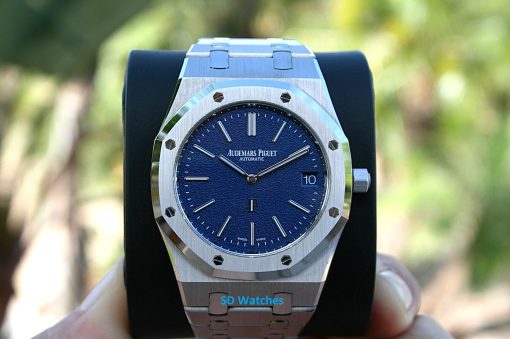 Audemars 16202BC | SD Watches Close-up of an Audemars Piguet stainless steel watch with a blue textured dial, date window at 3 o'clock, on a display stand.