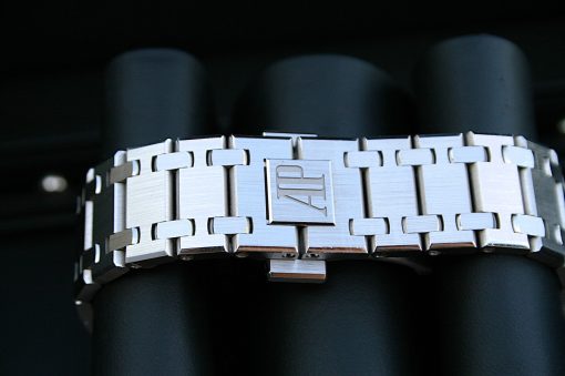 IMG_6359 | SD Watches Close-up of a stainless steel watch bracelet with the AP logo on the clasp, resting on a dark surface.