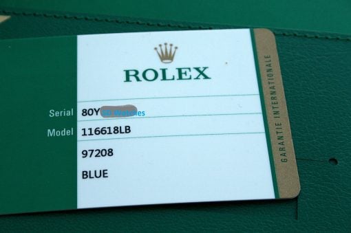 IMG_6487 | SD Watches Close-up of a Rolex warranty card in a green holder, displaying the Rolex crown, 'ROLEX' text, and model number 116618LB with a partially visible serial number.