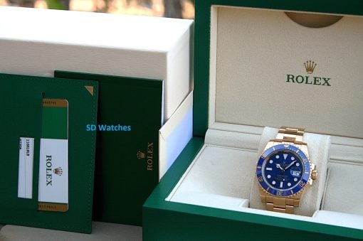 IMG_6489 | SD Watches Open Rolex display box showing a gold Rolex Submariner with blue bezel and blue dial in a beige interior, branded Rolex box visible