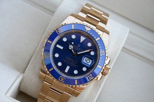 IMG_6494 | SD Watches Gold Rolex Submariner with blue bezel and blue dial in a display case, showing date window at 3 o'clock.