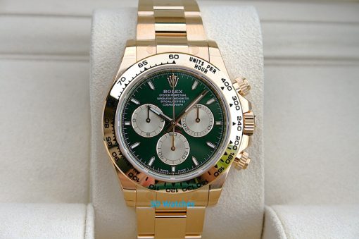 Rolex 126508 John Mayer | SD Watches Gold Rolex chronograph watch with a green dial on a padded display cushion, close-up view