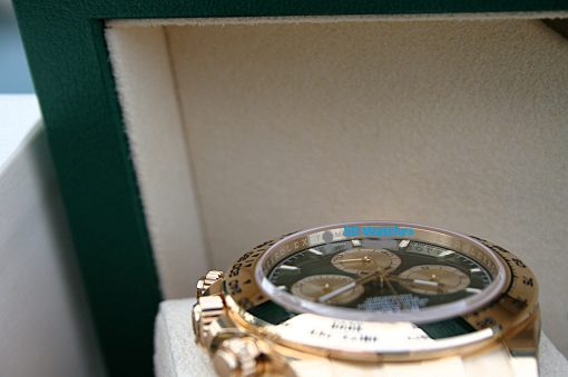 IMG_6525 | SD Watches Close-up of a gold Rolex wristwatch in a green presentation box, showing its detailed dial and bezel.