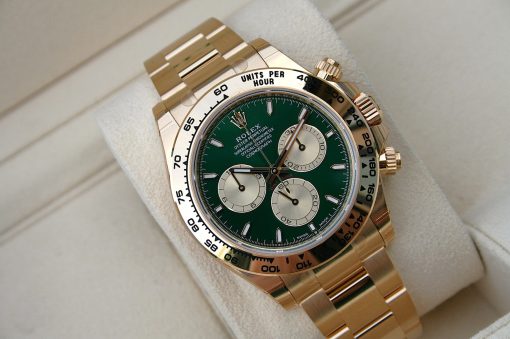 IMG_6530 | SD Watches Gold Rolex Oyster Perpetual Cosmograph watch with green dial and multiday chronograph subdials resting on a light fabric surface