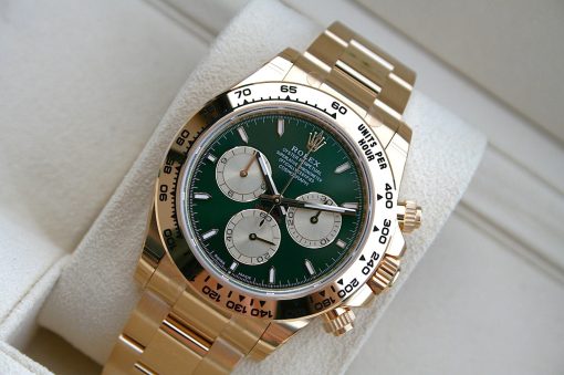 IMG_6533 | SD Watches Gold Rolex Daytona chronograph with a green dial and silver subdials, resting on a soft beige cushion.