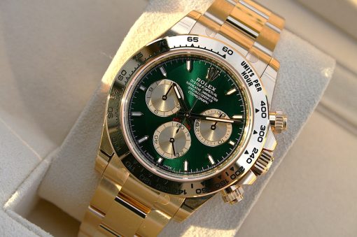 IMG_6534 | SD Watches Close-up of a gold Rolex wristwatch with a green dial and silver subdials on a padded display cushion.
