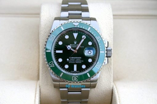 Rolex 116610LV | SD Watches Green-bezel Rolex Submariner with stainless steel bracelet on a beige cushion display