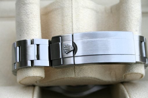 IMG_6545 | SD Watches Close-up of a silver Rolex watch bracelet clasp with the crown logo, wrapped around a beige mannequin hand/bracelet band details visible.