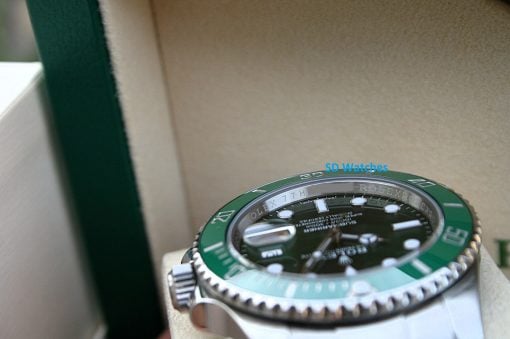 IMG_6546 | SD Watches Close-up of a Rolex watch with a green bezel in a beige display case.