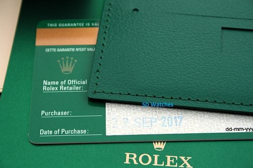 IMG_6552 | SD Watches Close-up of a green Rolex warranty card peeking from under a green leather wallet, showing 'Name of Official Rolex Retailer' and 'Date of Purchase' fields.