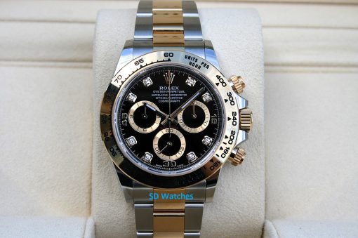 Rolex 116503 | SD Watches Two-tone Rolex Daytona watch with black dial, diamond hour markers, on a beige display cushion.