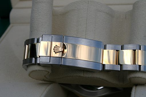 IMG_6682 | SD Watches Close-up of a two-tone Rolex watch bracelet with a crown-logo clasp resting on a padded display
