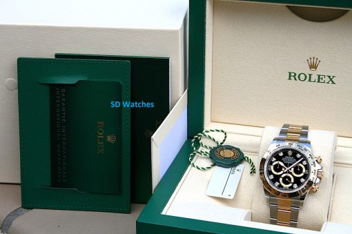 IMG_6687 | SD Watches Rolex wristwatch displayed in its beige interior of a green presentation box, with tags nearby and a glossy two-tone band visible