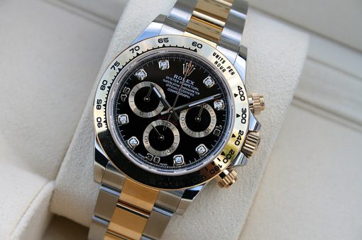 IMG_6693 | SD Watches Close-up of a two-tone Rolex Daytona chronograph with a black dial and diamond hour markers on a gold and steel bracelet