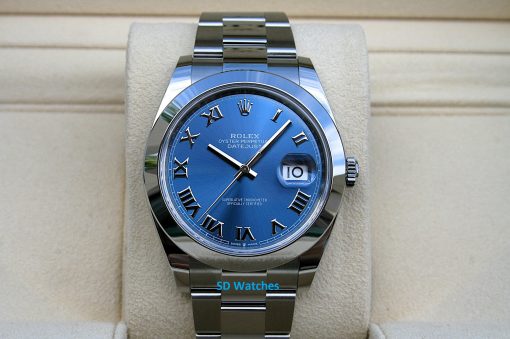 Rolex 126300 | SD Watches Blue Rolex Datejust wristwatch with Roman numerals and date window on a beige display pillow. (informative)