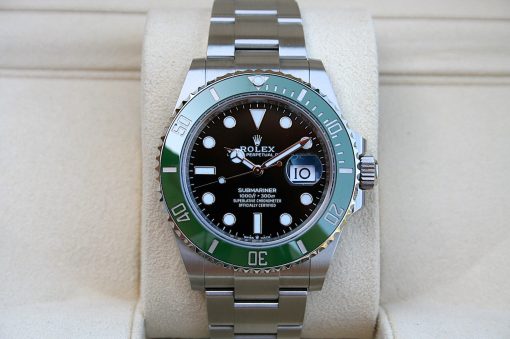 IMG_6790 | SD Watches Close-up of a Rolex Submariner stainless steel watch with a black dial and green bezel on a beige display cushion