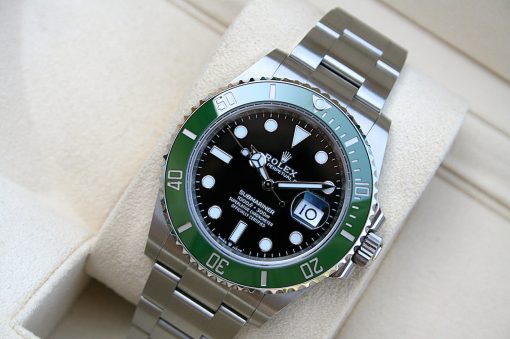 IMG_6792 | SD Watches Stainless steel Rolex Submariner with a black dial and green bezel resting on a light display cushion.
