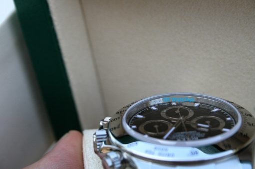 IMG_6831 | SD Watches Close-up of a silver chronograph wristwatch with a black dial and rotating bezel, held in a hand.