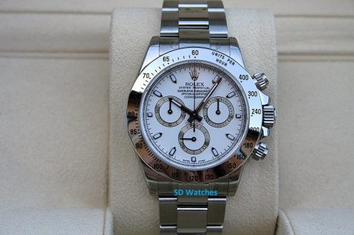 Rolex 116520 NIB | SD Watches Rolex Daytona watch with white dial and silver tachymeter bezel on a beige display stand