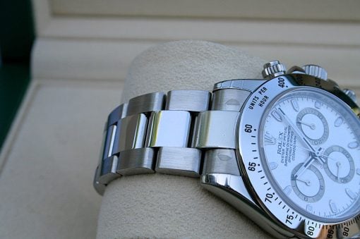 IMG_6847 | SD Watches Close-up of a silver stainless steel wristwatch with a white dial and tachymeter bezel resting on a beige cushion.