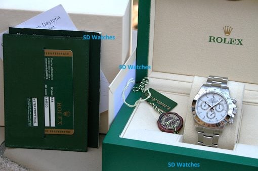 IMG_6857 | SD Watches Rolex watch in a beige display box with a green outer case and tags nearby (watch visible on right).