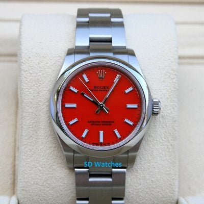 Rolex 277200 Red Coral | SD Watches Close-up of a stainless steel Rolex watch with a bright red dial on a cushioned display lapel/stand, showcasing the bracelet and bezel.