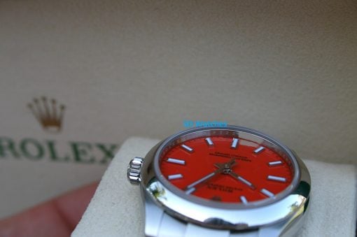 IMG_6768 | SD Watches Close-up of a stainless steel Rolex watch with an orange dial; 'SD Watches' blue text overlays the image.