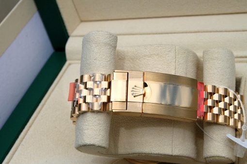 IMG_6898 | SD Watches Gold metal Rolex-style watch band with crown clasp resting on a beige display cushion in a green-edged box