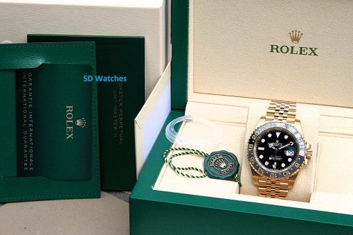 IMG_6902 | SD Watches Gold Rolex GMT-Master II in a green and beige presentation box with warranty card nearby.