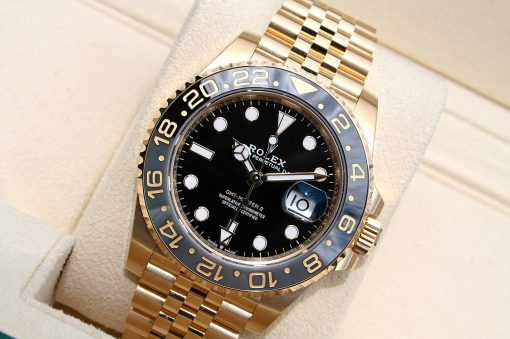 IMG_6907 | SD Watches Gold Rolex watch with black dial and ceramic bezel on a beige cushion; Jubilee bracelet visible.