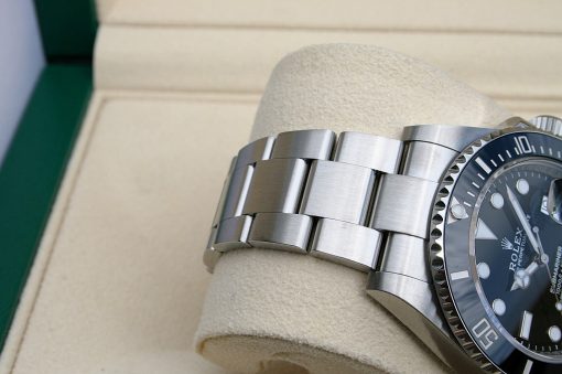 IMG_6912 | SD Watches Close-up of a stainless steel Rolex watch bracelet lying on a beige display cushion.
