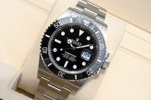 IMG_6924 | SD Watches Close-up of a Rolex Submariner watch with black dial and stainless steel bracelet in a beige presentation box.
