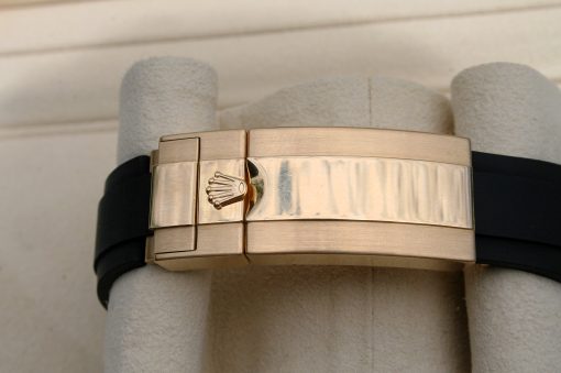 IMG_6932 | SD Watches Close-up of a rose-gold Rolex bracelet clasp with the crown logo on a beige display cushion.