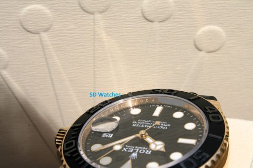 IMG_6933 | SD Watches Close-up of a black and gold Rolex watch, showing the bezel and detailed dial.