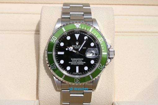 Rolex 16610LV | SD Watches Rolex Submariner diver's watch with a green bezel and black dial on a beige display pillow