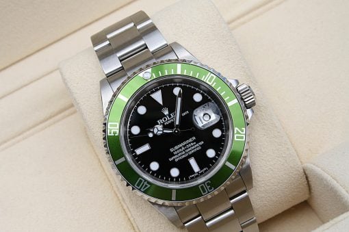 IMG_6953 | SD Watches Rolex Submariner wristwatch with a black dial and green bezel resting on a beige cushion.