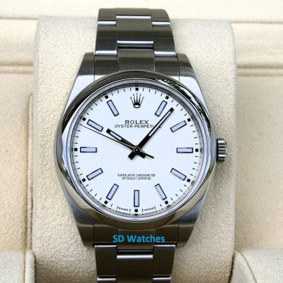 Rolex Oyster Perpetual wristwatch with a white dial and stainless steel bracelet displayed on a beige cushion.