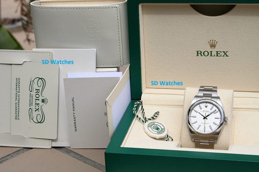 IMG_6977 | SD Watches Rolex watch in an open green presentation box with papers and security tags nearby