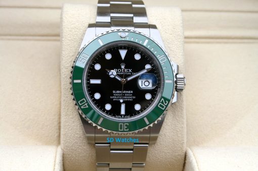 Rolex 126610LV | SD Watches Rolex Submariner watch with black dial and green bezel on a beige display cushion.