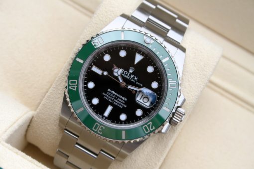 IMG_7087 | SD Watches Close-up of a stainless steel dive watch with a green bezel, black dial, and date window magnifier on a beige cushion.