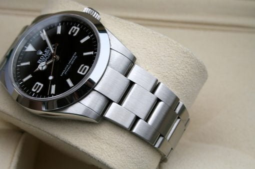 IMG_7090 | SD Watches Close-up of a stainless steel Rolex watch with a black dial resting on a beige cushion.