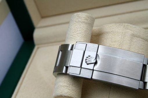 IMG_7092 | SD Watches Close-up of a stainless steel Rolex watch bracelet with the crown logo on a beige towel nearby.