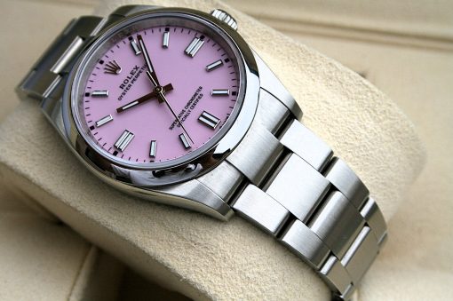 IMG_7107 | SD Watches Close-up of a stainless steel Rolex watch with a pink dial and silver hour markers resting on a beige cushion.
