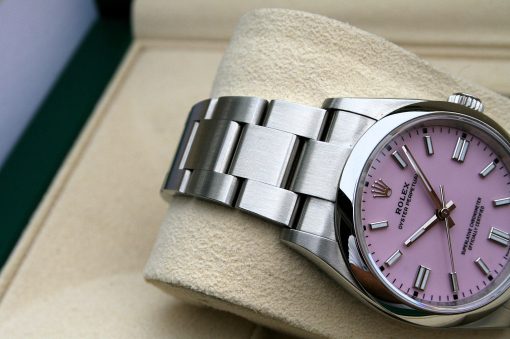IMG_7108 | SD Watches Close-up of a stainless steel Rolex wristwatch with a pink dial resting on a beige cushion.