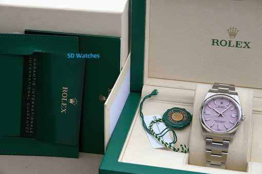 IMG_7116 | SD Watches Rolex watch with pink dial in beige presentation box, stainless steel bracelet, alongside green Rolex packaging and certification tags inside the box.