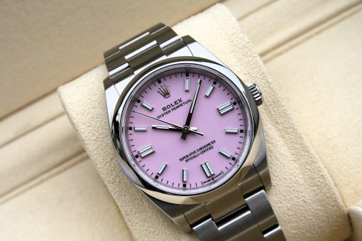 IMG_7117 | SD Watches Close-up of a stainless steel Rolex Oyster Perpetual watch with a pink dial resting on a beige cushion.