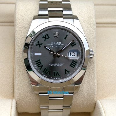 Rolex Oyster Perpetual Datejust stainless steel watch on a beige display cushion.