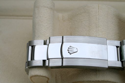 IMG_7126 | SD Watches Close-up of a stainless steel watch bracelet with the Rolex crown logo on the clasp, resting on a beige towel.